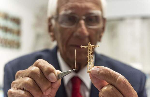 Philip holds the wooden frame for his model matchstick fleet - he spent 70 years perfecting the craft