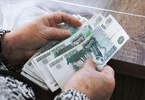 Пожилая жительница получает выплату в рублях