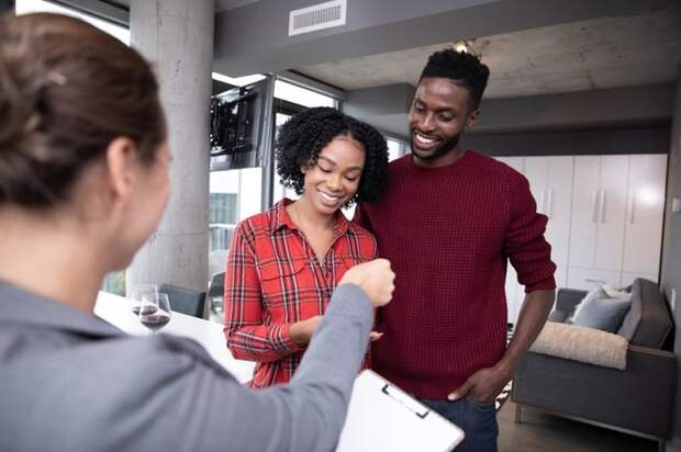 Happy couple receiving keys to their new home.
