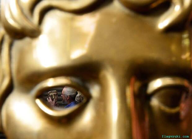 Управляющий директор компании New Pro Foundry Патрик Хелли позирует с бронзовой маской Британской академии кино и телевизионных искусств (BAFTA) в литейном цехе в западном Лондоне.