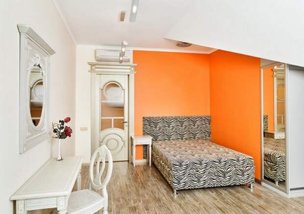 оранжевая стена в нейтральной спальне