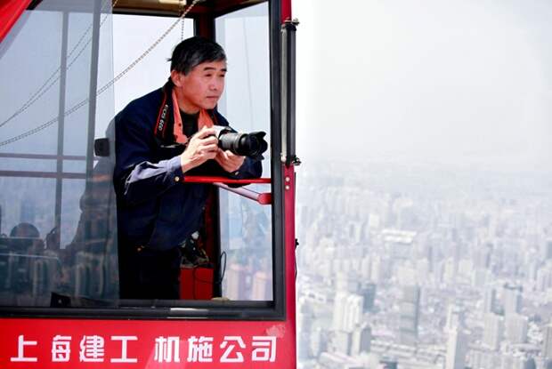 Крановщик Вэй Gensheng в его крана над Шанхаем, Китай.