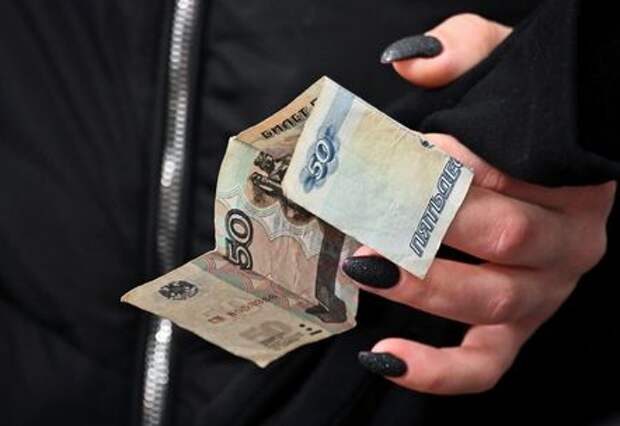 A customer holds a Russian 50-rouble banknote in a grocery store in Omsk, Russia March 31, 2021. REUTERS/Alexey Malgavko