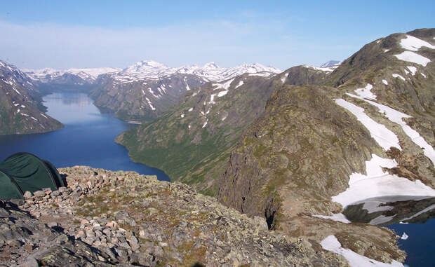 Йотунхеймен Норвегия Норвежский Йотунхеймен известен и под другим именем — туристы и местные предпочитают называть его «Землей гигантов». Тут, среди двух сотен гор, и в самом деле могло бы с комфортом разместиться целое великанье племя. Сказочный пейзаж дополняется ярко-голубыми озерами, наполненными талой водой.