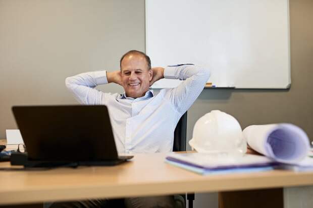 A smiling person at a laptop.