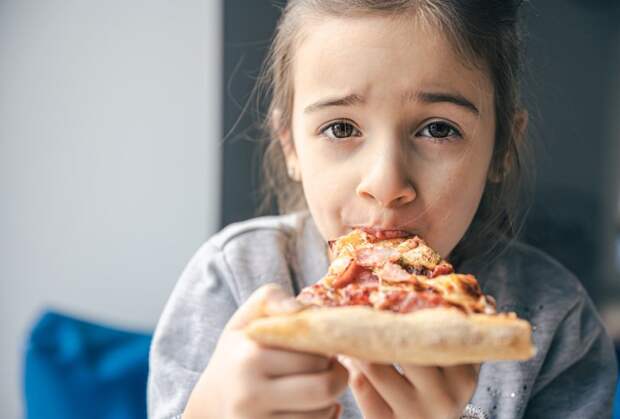 Девочка ест пиццу