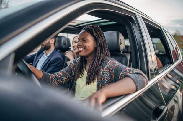A woman driving a car with multiple passengers.