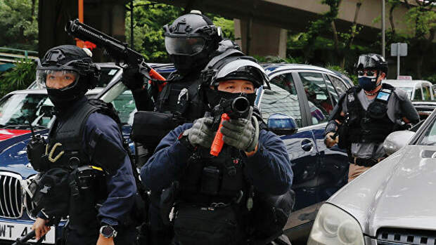 Сотрудники спецслужб во время протеста против закона о национальной безопасности Гонконга