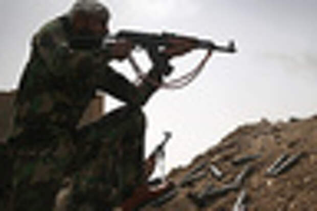 A volunteer from the Badr Brigade militia fires on ISIS fighters from the frontline on April 11, 2015 in Ebrahim Ben Ali, in Anbar Province, Iraq. Shia militia and Iraqi government troops are preparing for an assault on ISIS forces in Anbar, much of which was captured by ISIS forces last year. 