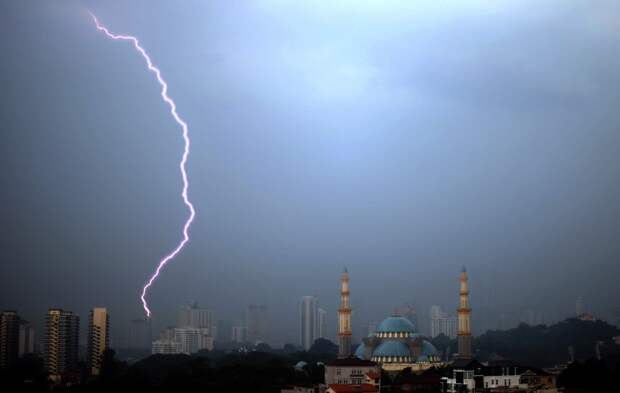 Молния пронзает небо недалеко от мечети в Куала-Лумпуре