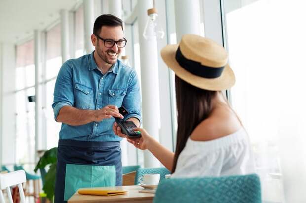 Woman paying waiter credit card