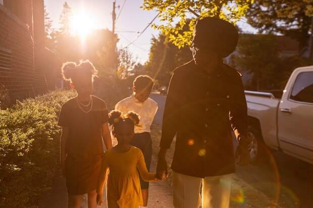 An online story published in March 2021 told of civil rights activism in Oregon, which had a law banning Black residents when it became a state in 1859. In this photo, Portland artist and activist Cleo Davis, Jr., walks with his children in their neighborhood.