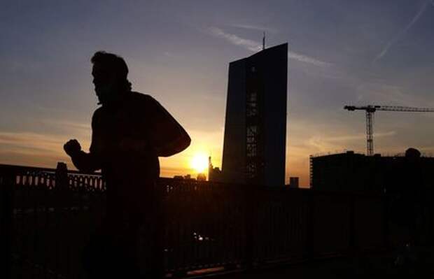 A runner passes the European Central Bank (ECB) headquarters during sunset as the spread of the coronavirus disease (COVID-19) continues in Frankfurt, Germany, April 8, 2021. REUTERS/Kai Pfaffenbach