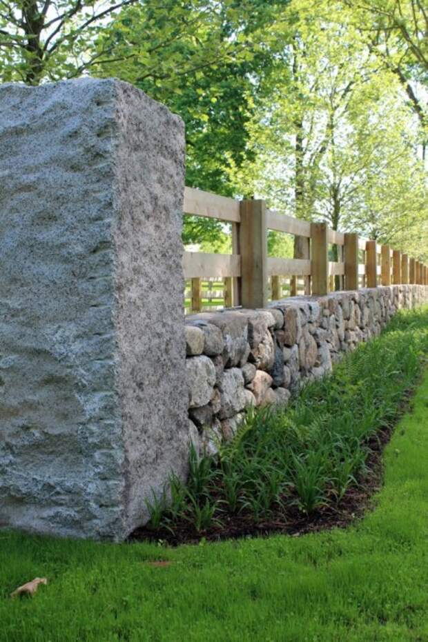 Комбинированный забор, в котором отлично сочетается дерево и камень может стать своеобразной визитной карточкой загородного участка. 
