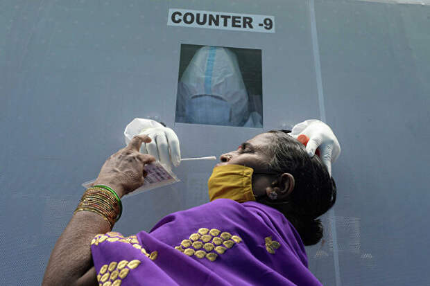Женщина в мобильном пункте сдачи теста на коронавирус в Хайдарабаде, Индия 