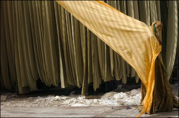 Улыбающаяся индийская женщина за работой на фабрике в Пали-Марвар.