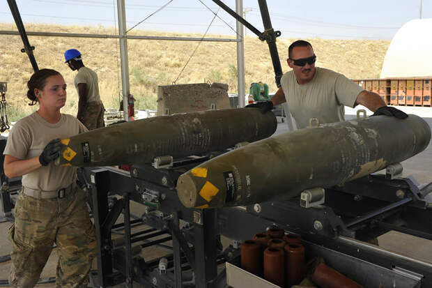 BAGRAM AIRFIELD, Afghanistan -- U.S. Air Force Airman 1st Class Casey Cain and Senior Airman Christopher Reed slide a GBU-38 on a conveyor during a bomb build here on Aug. 14, 2014. Cain is a reservist from the 442nd Fighter Wing, Whiteman AFB, Mo. and a