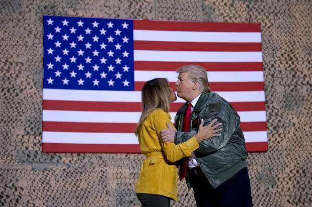 Президент Дональд Трамп целует первую леди Меланию Трамп во время митинга на авиабазе Аль-Асад, Ирак, среда, 26 декабря 2018 года. Эндрю Харник, AP…